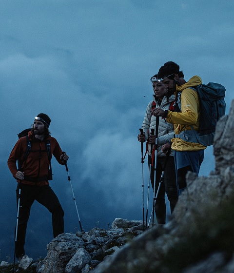 Leki Outdoor Imagebild - drei Personen mit Wanderstöcken bei Dämmerung im Gebirge