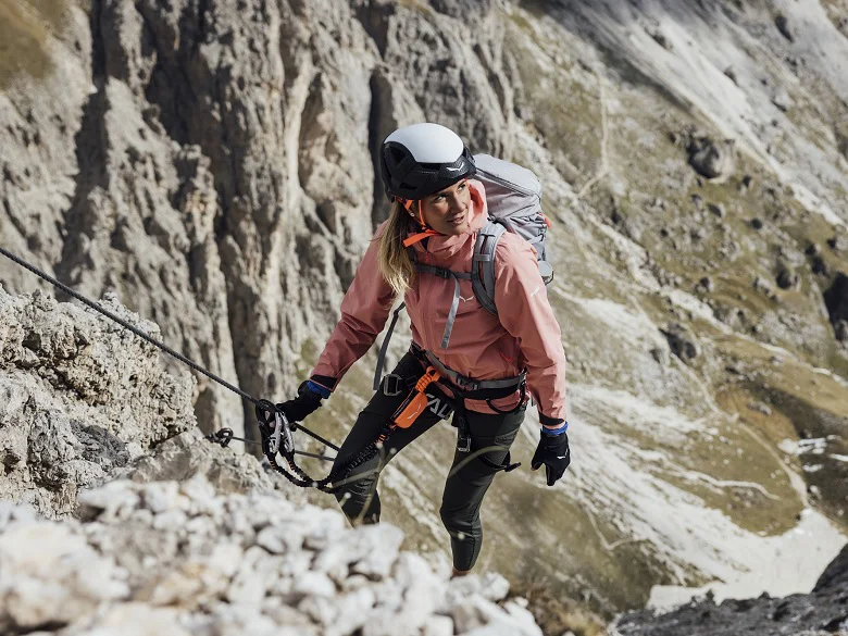 Outdoor Imagebild - Person im Gebirge an einem Klettersteig, ausgerüstet mit Sicherung und Kletterhelm