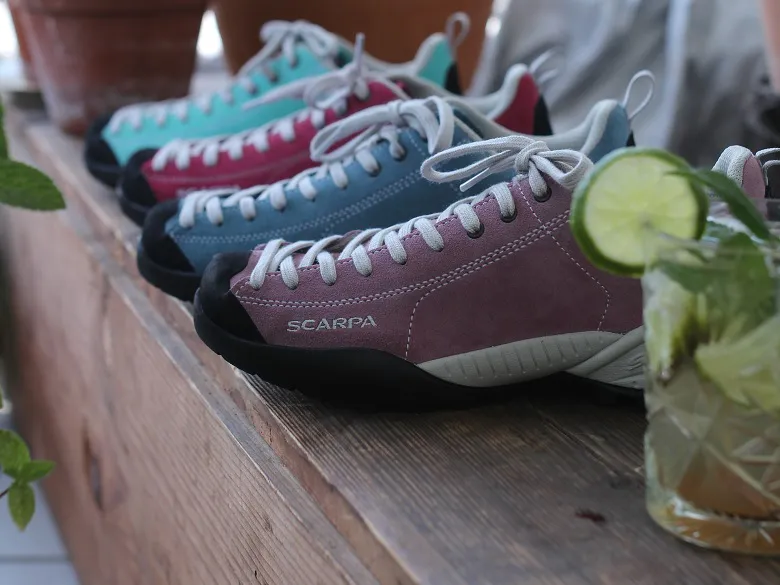 Scarpa Mojtio Schuhmodelle aufgereiht und im Vordergrund ein Glas Mojito