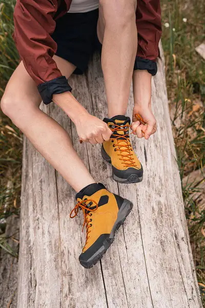 Scarpa Mojito Schuhe in Aktion - jemand bindet einen orangefarbenen Scarpa Schuh