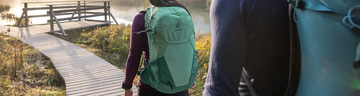 deuter Futura Rucksäcke in Aktion - Zwei Personen wandern auf einem hölzernen Steg und tragen deuter Futura Rucksäcke