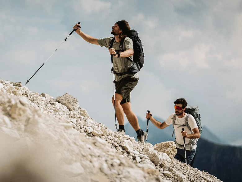 Outdoor Imagebild - zwei Personen mit Wanderstöcken gehen einen Berg hinauf