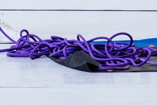 violettes Kletterseil liegt auf einer Seilplane am Boden einer Kletterhalle
