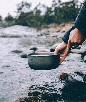 Trangia Topf vor einem Gewässer mit felsigem Ufer