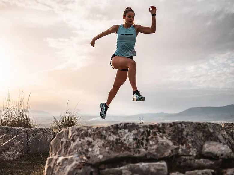 Outdoor Imagebild - Person springt über einen Felsen im freien