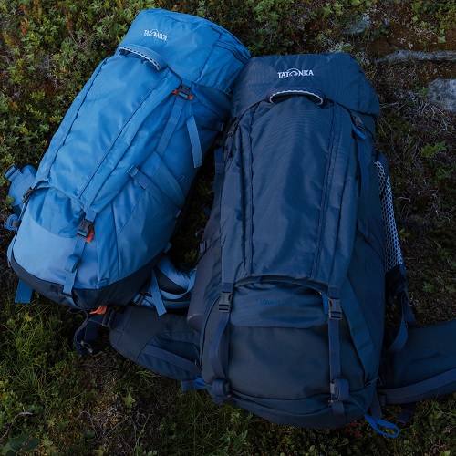 zwei blaue Tatonka Yukon Rucksäcke liegen auf einem Boden