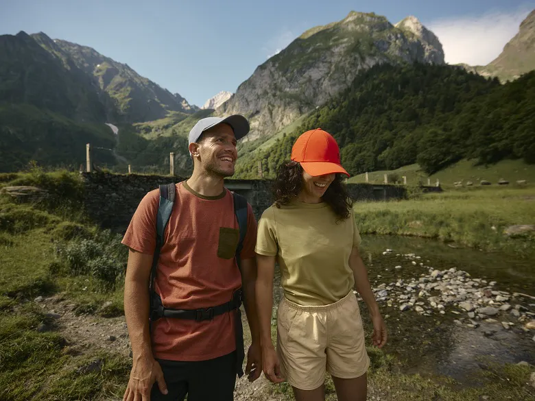 Outdoor Caps im Einsatz - zwei Personen mit Schildkappen in den Bergen. im Hintergrund ist ein Bach