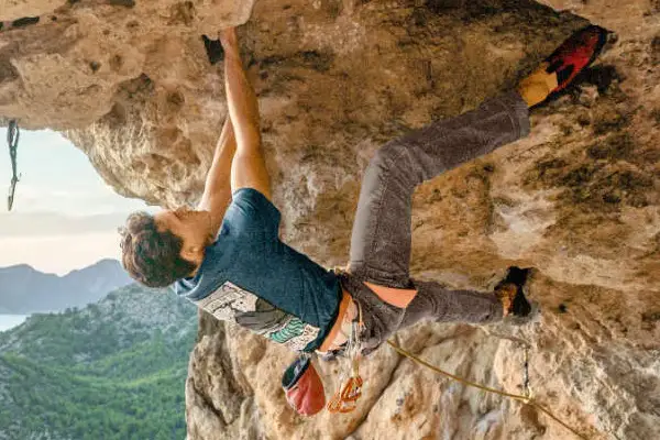 Klettergurt in Aktion - eine Person klettert an einer Felswand im Überhang